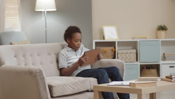 Happy Boy Using Tablet on Couch