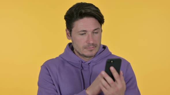 Man Using Smartphone, Yellow Background 