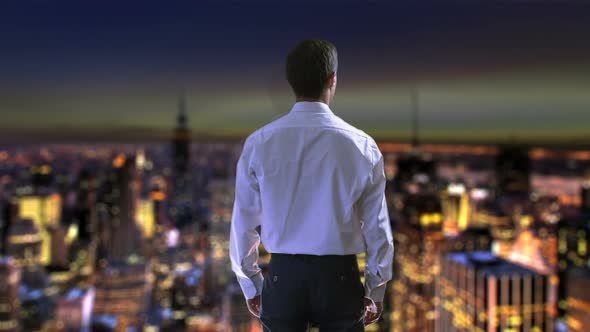 Businessman Viewing Night City From Skyscraper, Raising Hands in Victory Success