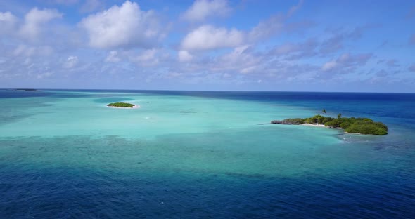 Wide above travel shot of a sunshine white sandy paradise beach and aqua turquoise water background 