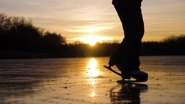 Cute Little Girl Is Going Skate Outdoors at Sunset. A Schoolgirl Enjoying Ice Skating at Frozen Lake