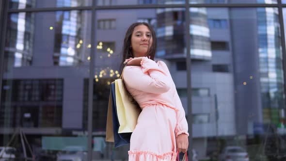 Young Girl in a Dress After Shopping with Bags in Hands