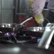 Chef Pours Fresh Oil Onto Frying Pans on Contemporary Stove - VideoHive Item for Sale