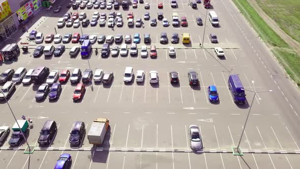 A bird's-eye view of parked cars in the parking lot near the shopping center.