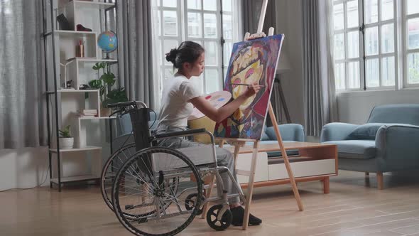 Artist Girl In Wheelchair Holding Paintbrush Mixed Colour Thinking And Painting A Girl On The Canvas