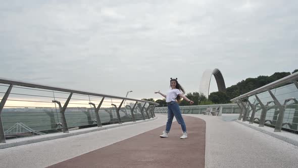 Happy Teen Girl Performing Stylish Dance on Bridge