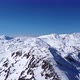 Aerial drone of an amazing panoramic view of a mountain range covered with snow during a sunny day - VideoHive Item for Sale
