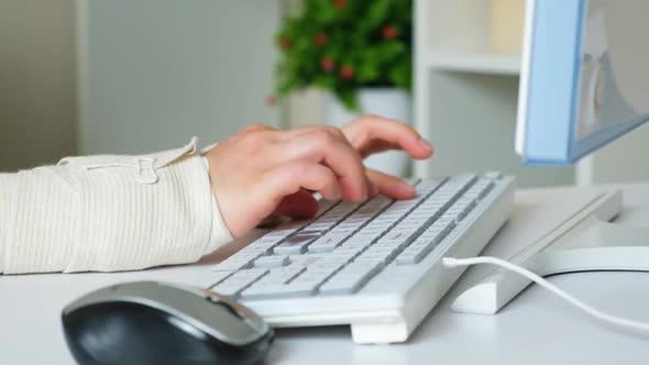 A Person with Carpal Tunnel Syndrome Types on a Keyboard