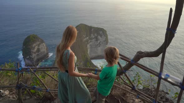 Young Woman and Her Little Son Tourists Visit the So-called Tyrannosaur Rock at the Kelingking Beach