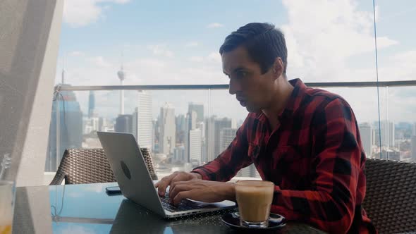 Happy Handsome Man Working on a Laptop Celebrates Successful Endeavor with YES Gesture