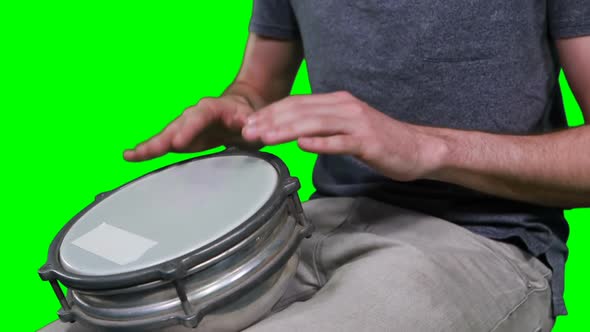 Mid section of drummer playing drum