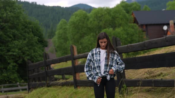 A Young Attractive Caucasian Female Stand By a Fence