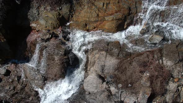 Aerial view of waterfall following it as it flows