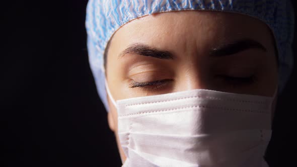 Female Doctor or Nurse in Face Mask Praying