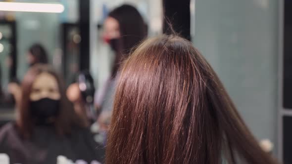 Master Works with Client Hair Using Brush and Dryer in Salon