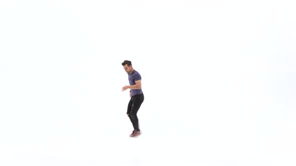 Man Is Dancing Breakdance on the White Background in Simple Grey T-shirt and Grey Jeans