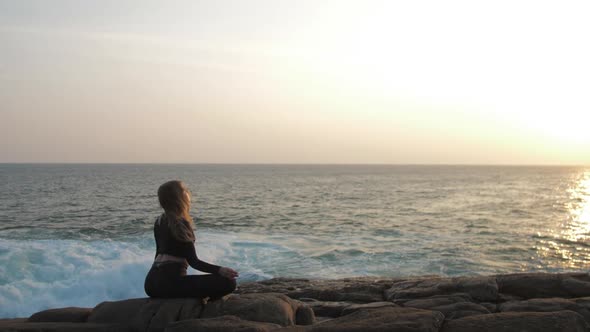 Girl Meditates in Yoga Pose Against Rising Summer Sun