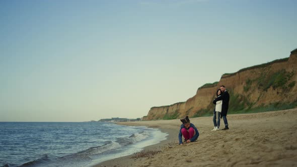 Young Family Enjoy Vacation at Ocean Beach Nature