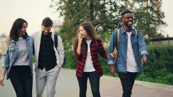 Slow Motion of Happy Friends Tourists Walking in the Street Smiling and Talking Then Doing High-five