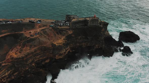 Lighthouse on Steep Cliff Near Ocean on Rainy Day Aerial