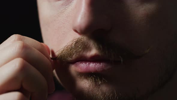 Close up of a man touching his mustache