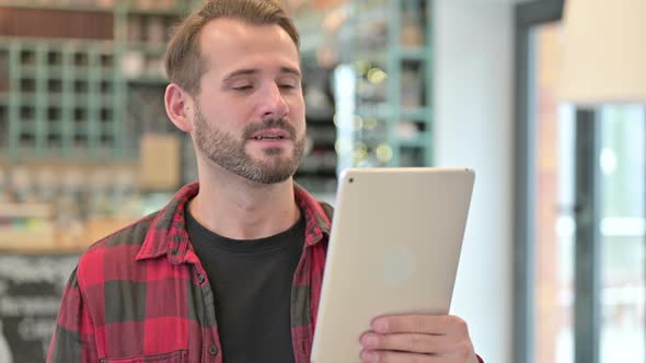 Portrait of Video Chat on Tablet By Young Man 