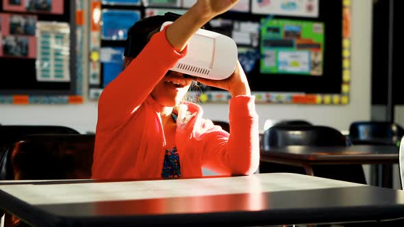 Schoolgirl using virtual reality headset in classroom 4k