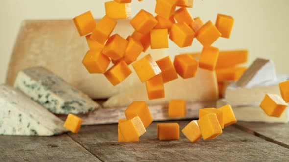 Super Slow Motion Shot of Cheddar Cubes Falling on Wooden Board at 1000 Fps.