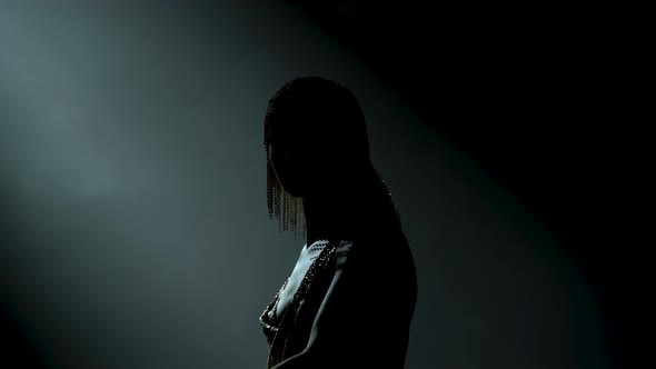 Silhouette of Dancing Greek Goddess Artemis on Stage in a Dark Studio with Smoke and Neon Lighting