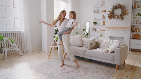 Young Happy Mother Caucasian Mommy Babysitter Woman Holding in Arms Hands Toddler Little Daughter