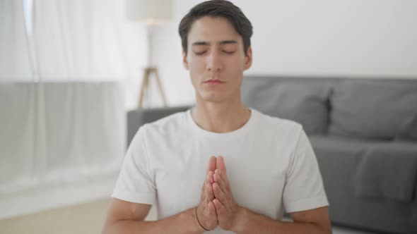 Close Up Relaxed Young Man in Sportswear Is Meditating in Lotus Position Sitting on Yoga Mat With