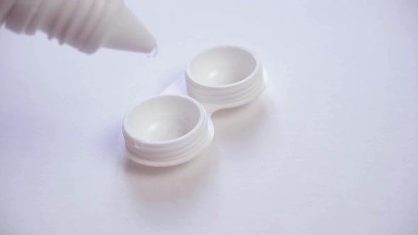 Lens Storage Solution is Poured Into a Plastic Lens Container