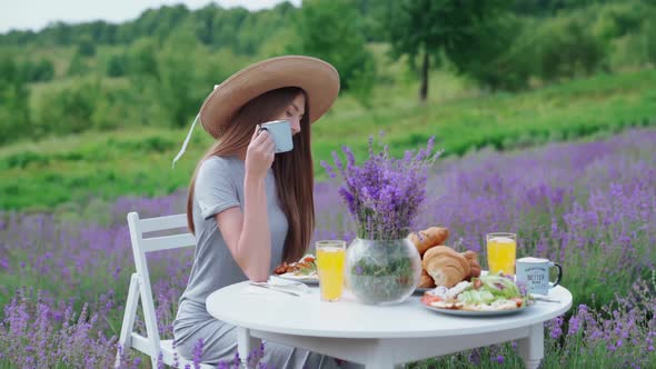 Woman Holding Coffee Cup in Lavender Field