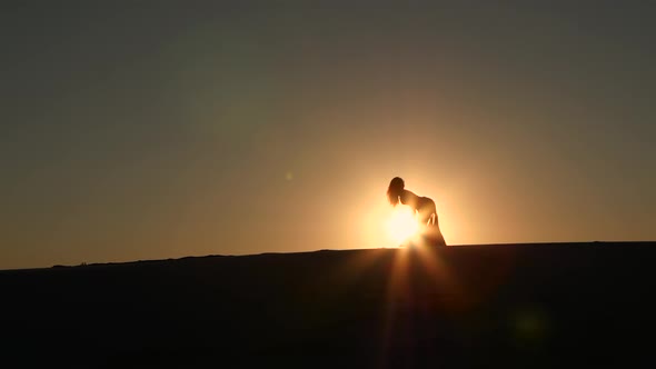 Professional Dancer Dances Gracefully Against the Background of a Hot Sunset. Silhouette
