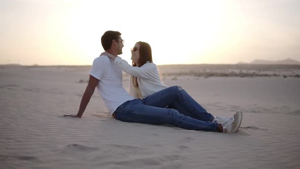 Young Man and Woman Sitting in Desert Beautiful Couple Girl and Guy Sand Dune Landscape Background