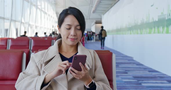 Businesswoman Check on The Cellphone and Wait for The Flight in The Airport