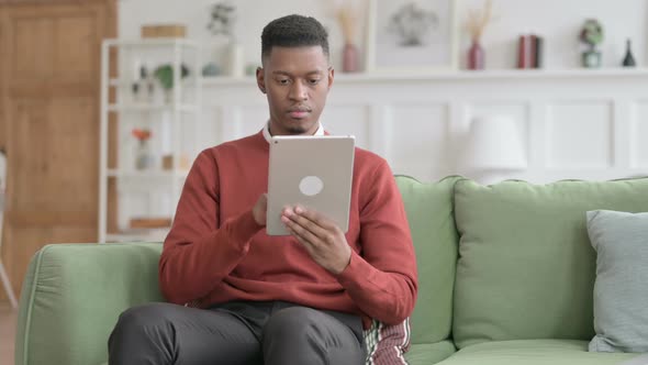 African Man using Tablet on Sofa