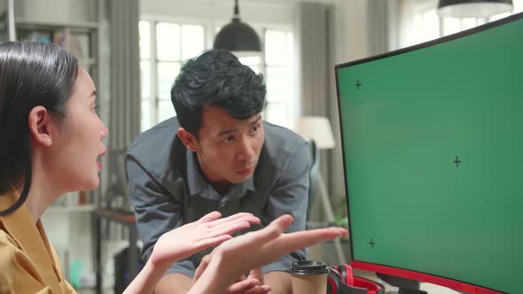 Female Arguing With Her Male Colleague On A Project On Her Computer With Mock-Up Green Screen