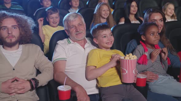 Parents with Kids on Knees Clapping Hands in Cinema.