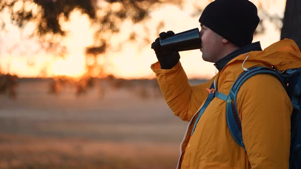 Hiker Young Tourist Enjoying Nature Drinking Hot Tea at Sunset