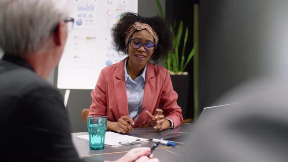 Afro-American Woman Speaking with Senior Colleague at Business Meeting