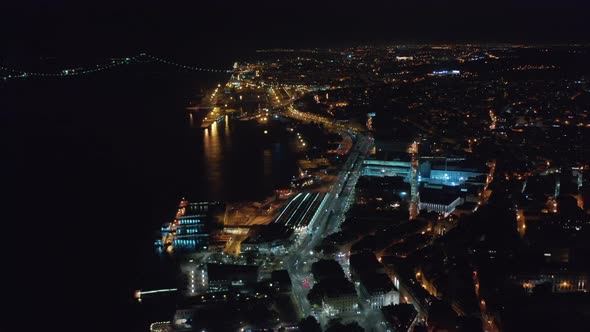 Stunning Night Aerial View of Houses and Ponte 25 De Abril Red Bridge in Urban City Center of Lisbon
