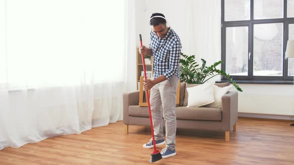 Man in Headphones with Broom Cleaning at Home 113
