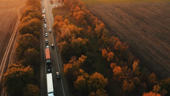 Aerial View of Cars Moving Towards Traffic Jam From Cars on Evening Country Road