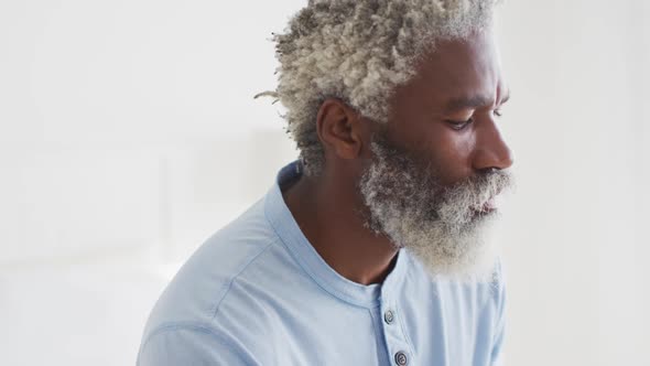 Stressed senior man sitting on bed at home