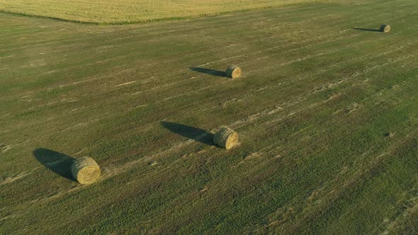 Aerial View Hay Bales at Agricultural Field in Summer at Sunset Haystack