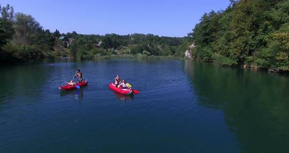 Aerial view of friends having fun paddling canoe