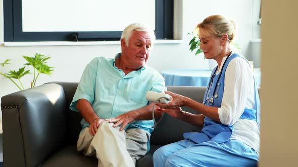 A nurse measuring blood pressure of a senior man