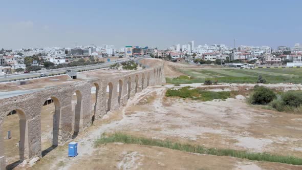 Aerial drone shot travelling over the Kamares Aqueduct arches of Larnaca towards town