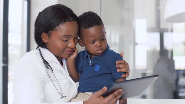 Doctor Showing Tablet Pc To Baby Patient at Clinic